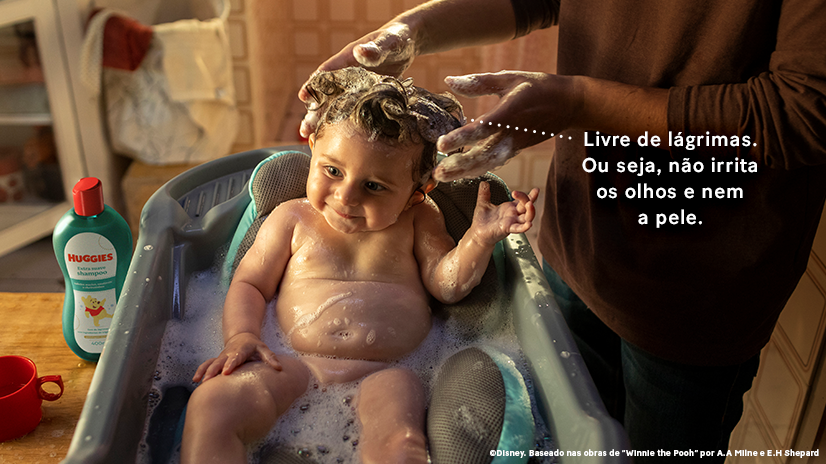 Bebê em banho de banheira com pai lavando seus cabelos. "Livre de lágrimas. Ou seja, não irrita os olhos e nem a pele."